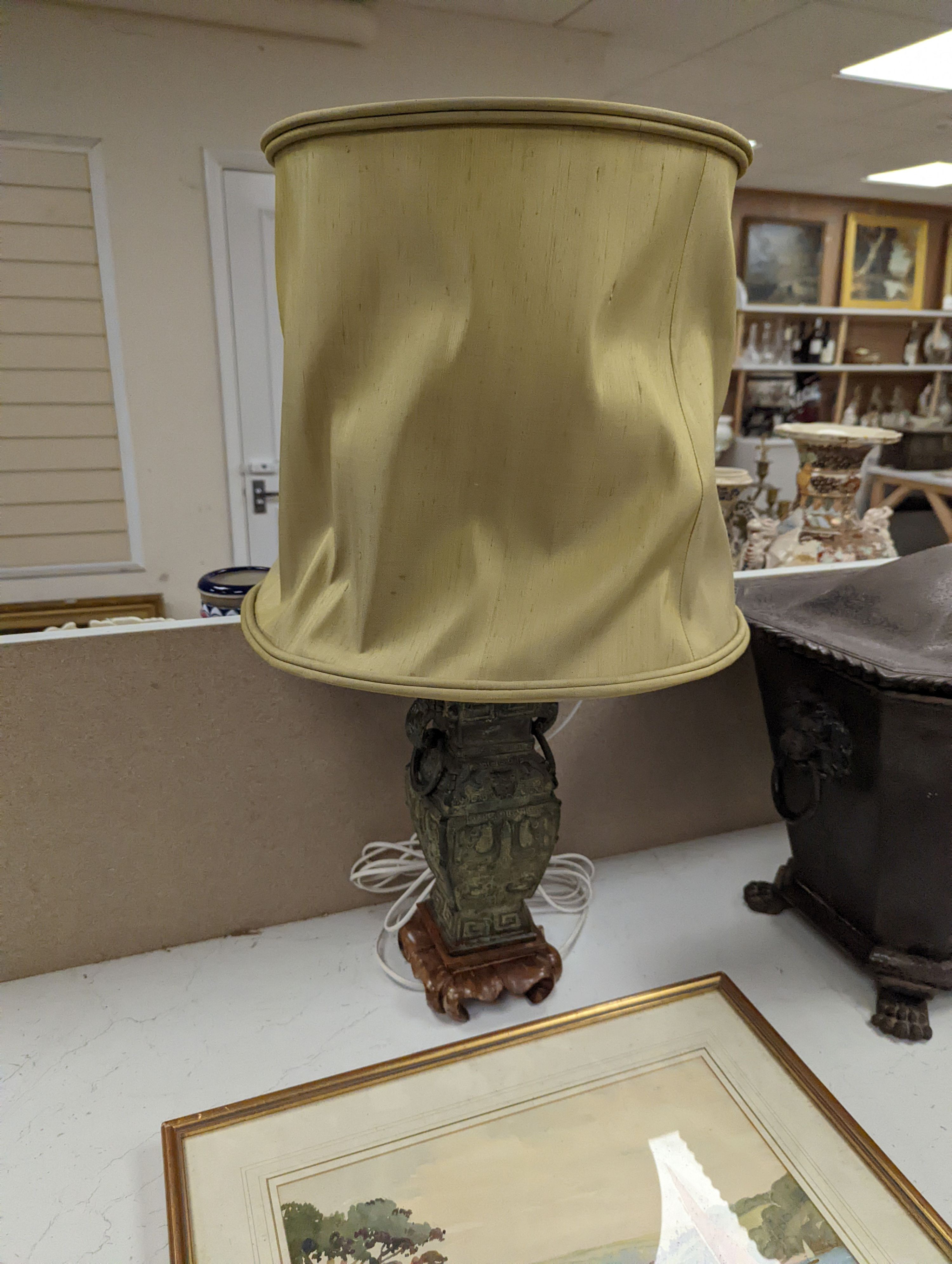 A pair of Chinese archaistic bronze lamps, 37 cms high not including shades or light fitting.